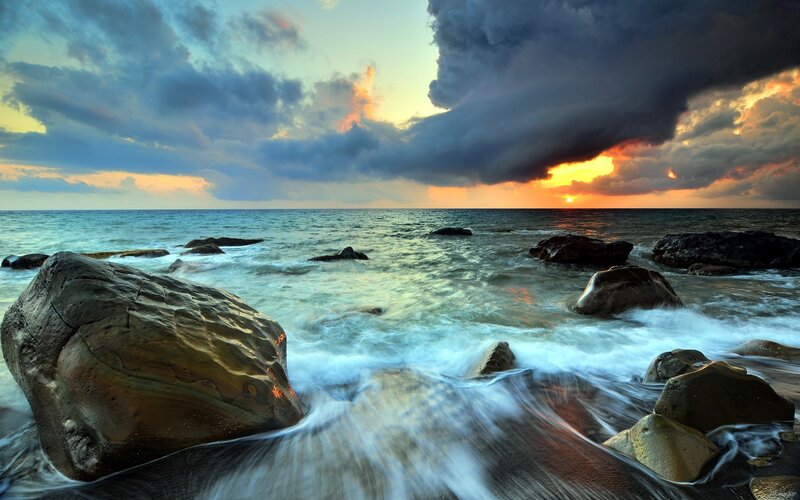 Stormy sunset at the rocky shore
