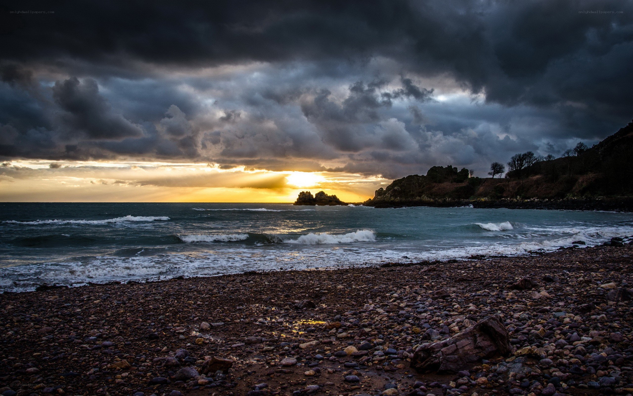 Stormy sunset over a pebble beach