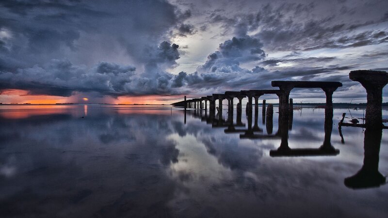 Stormy sunset over a ruined pier