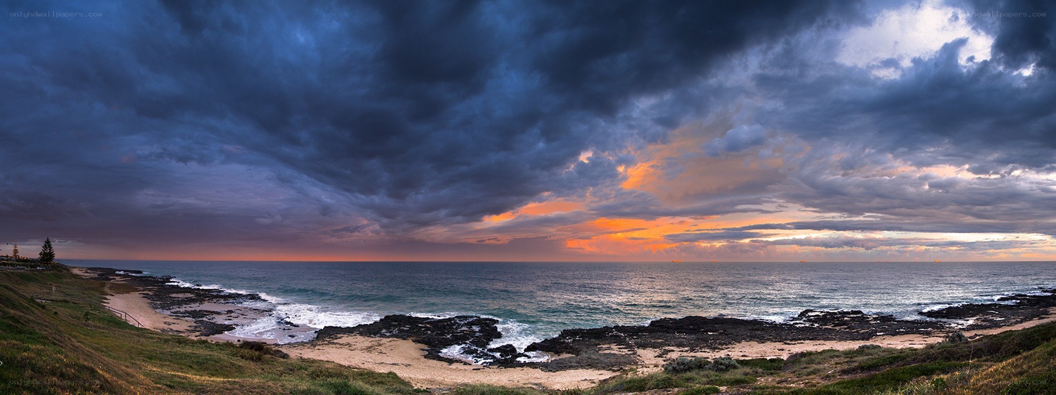 Stormy sunset over coastal rocks