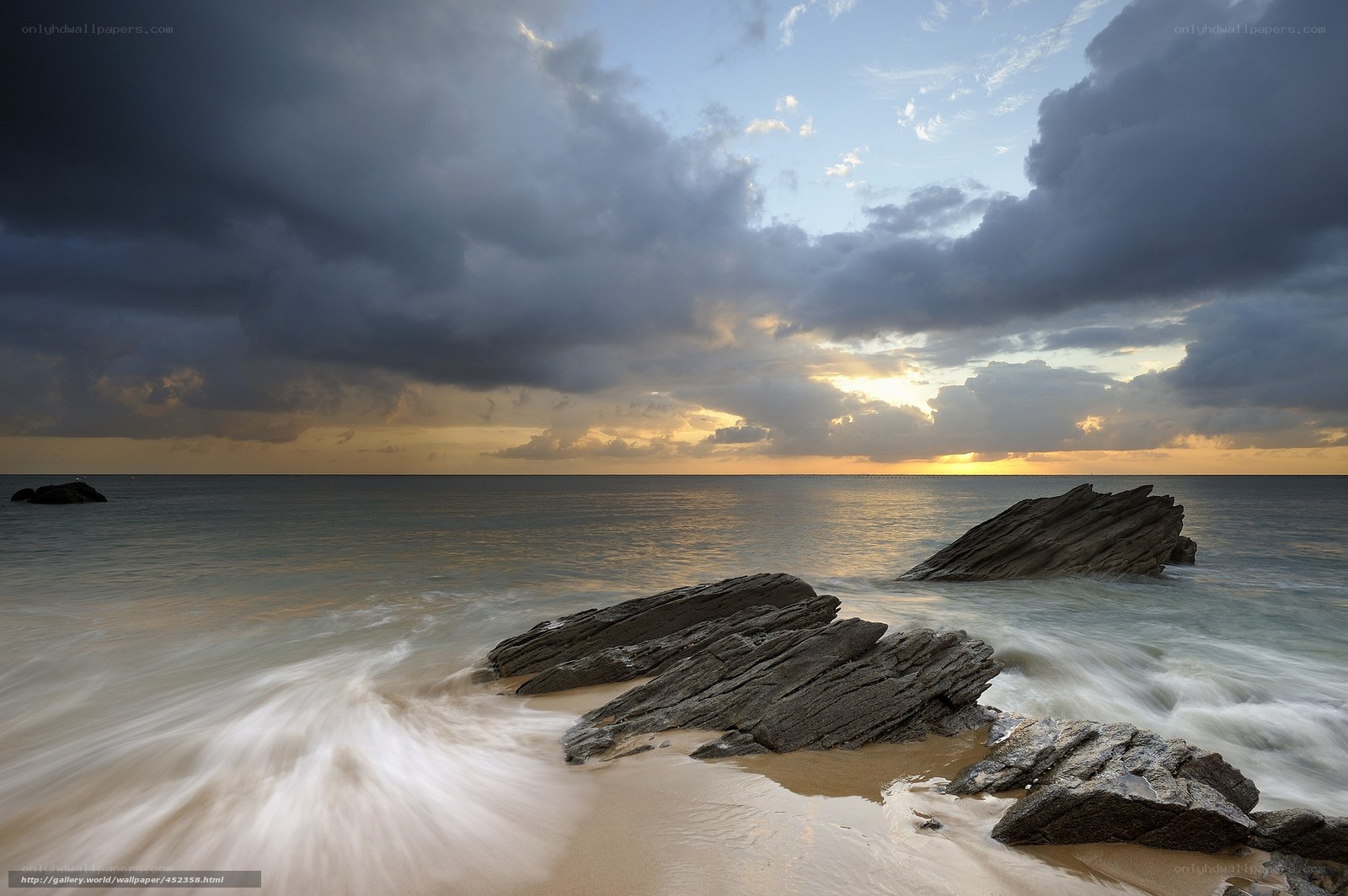 Stormy sunset over rocky beach