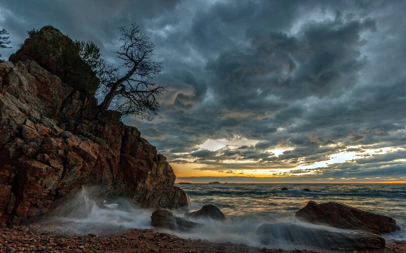 Stormy sunset over rocky coast