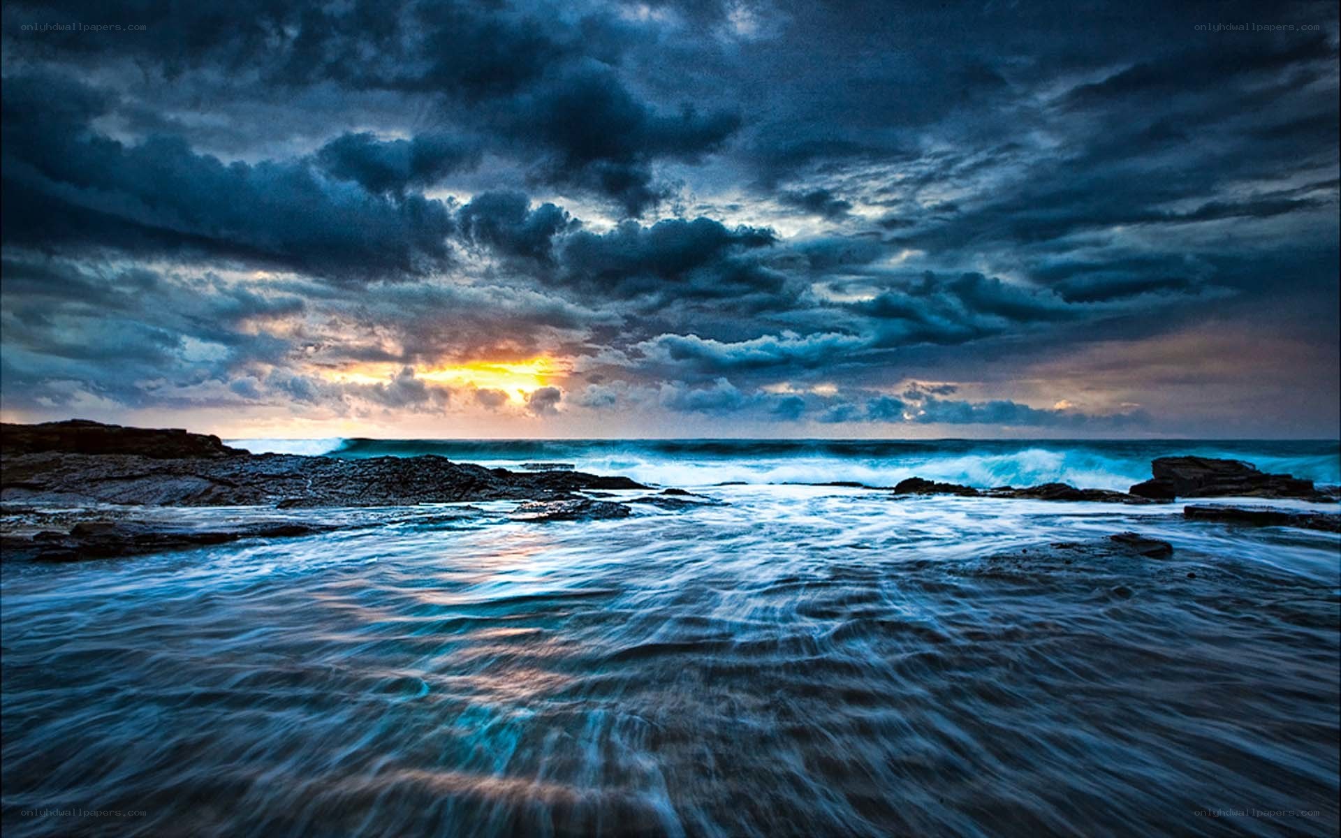 Stormy sunset over rocky shore