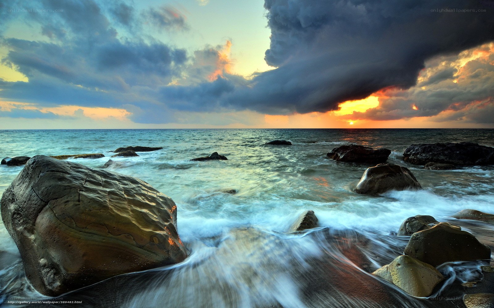 Stormy sunset over rocky shore