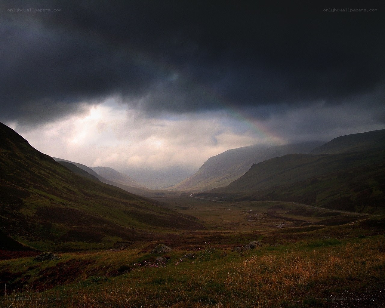 Stormy valley with rainbow