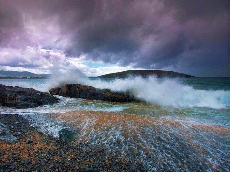Stormy waves crash on rocky shore