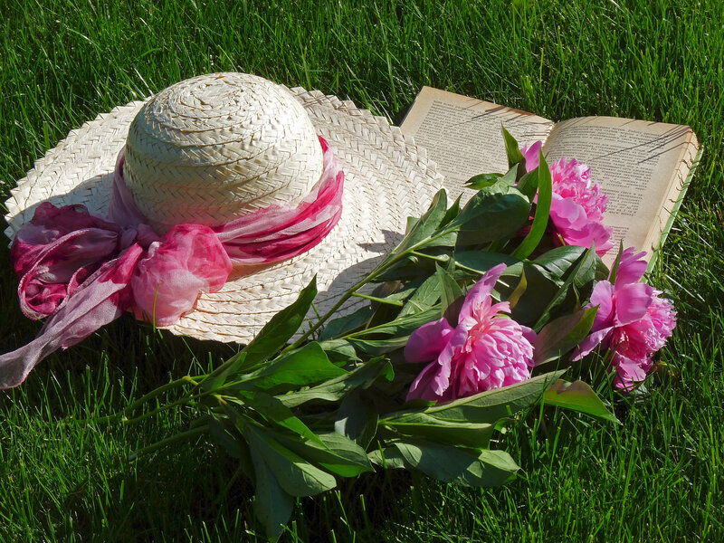 Straw hat with flowers on grass