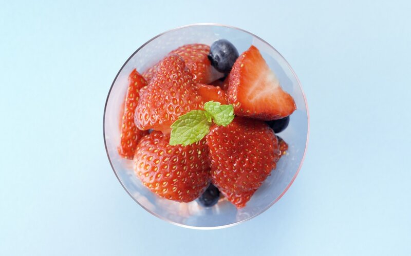 strawberries and blueberries in glass