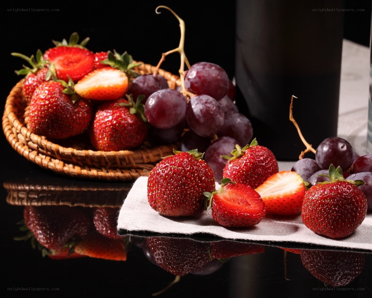 Strawberries and grapes on black