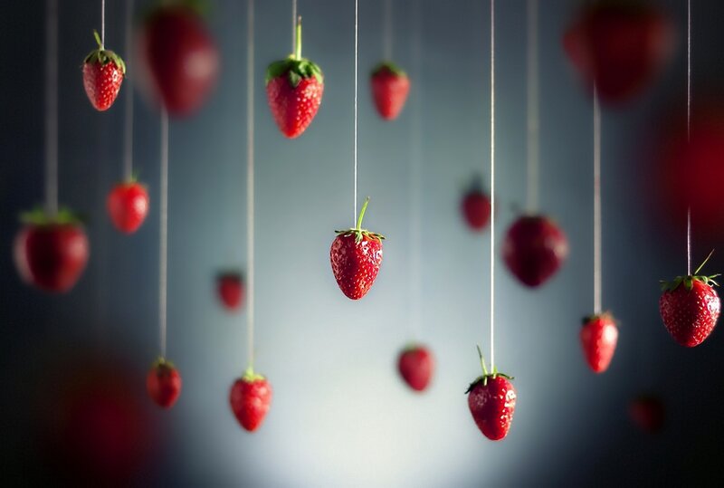 Strawberries hanging from strings
