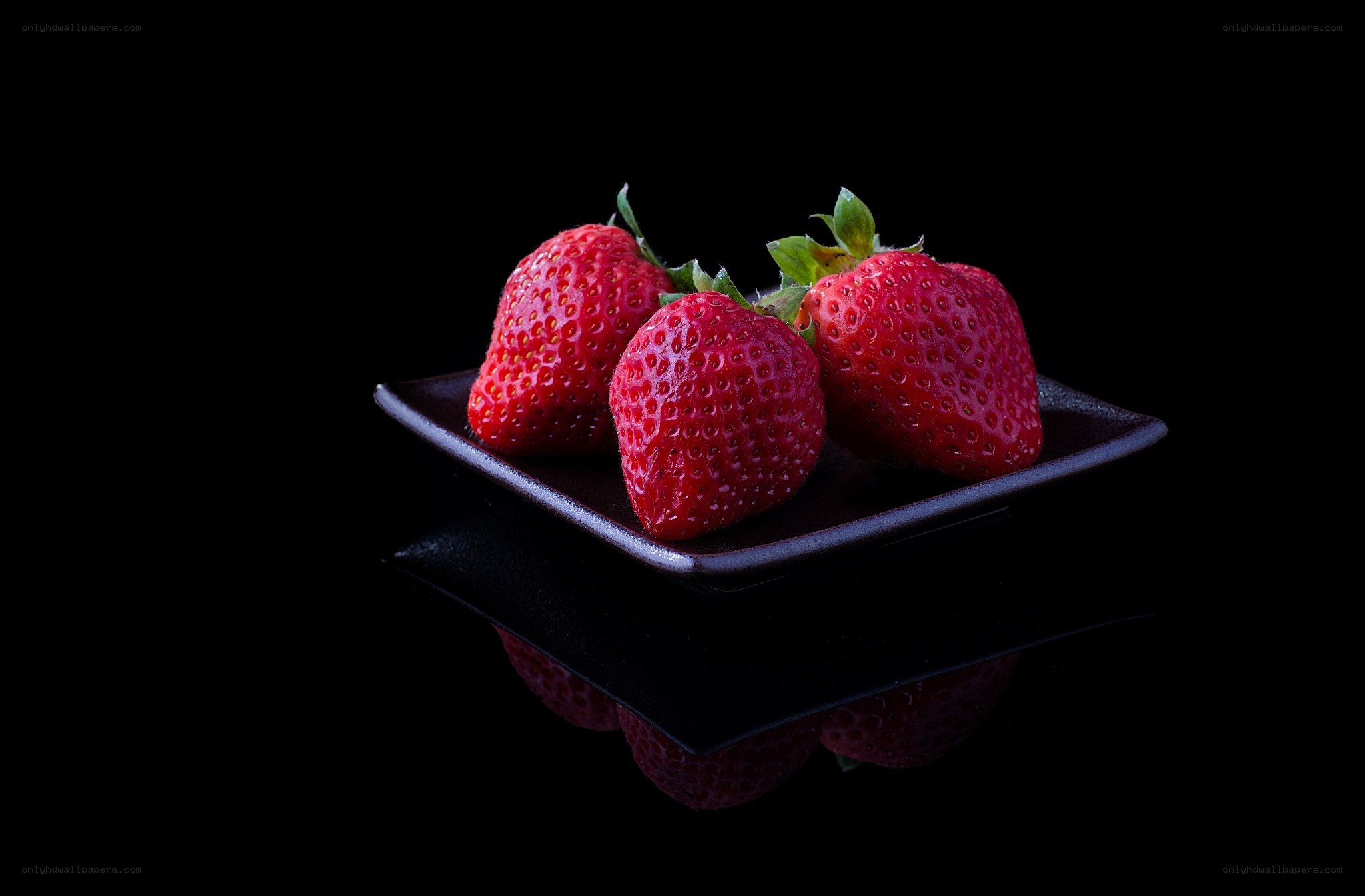Strawberries on a black plate