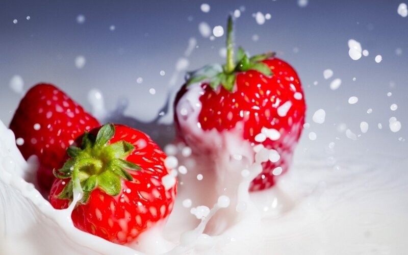 strawberries splashing in milk