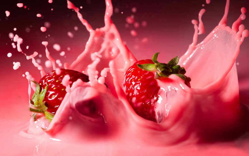 strawberries splashing in pink liquid