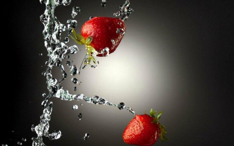 Strawberries splashing in water