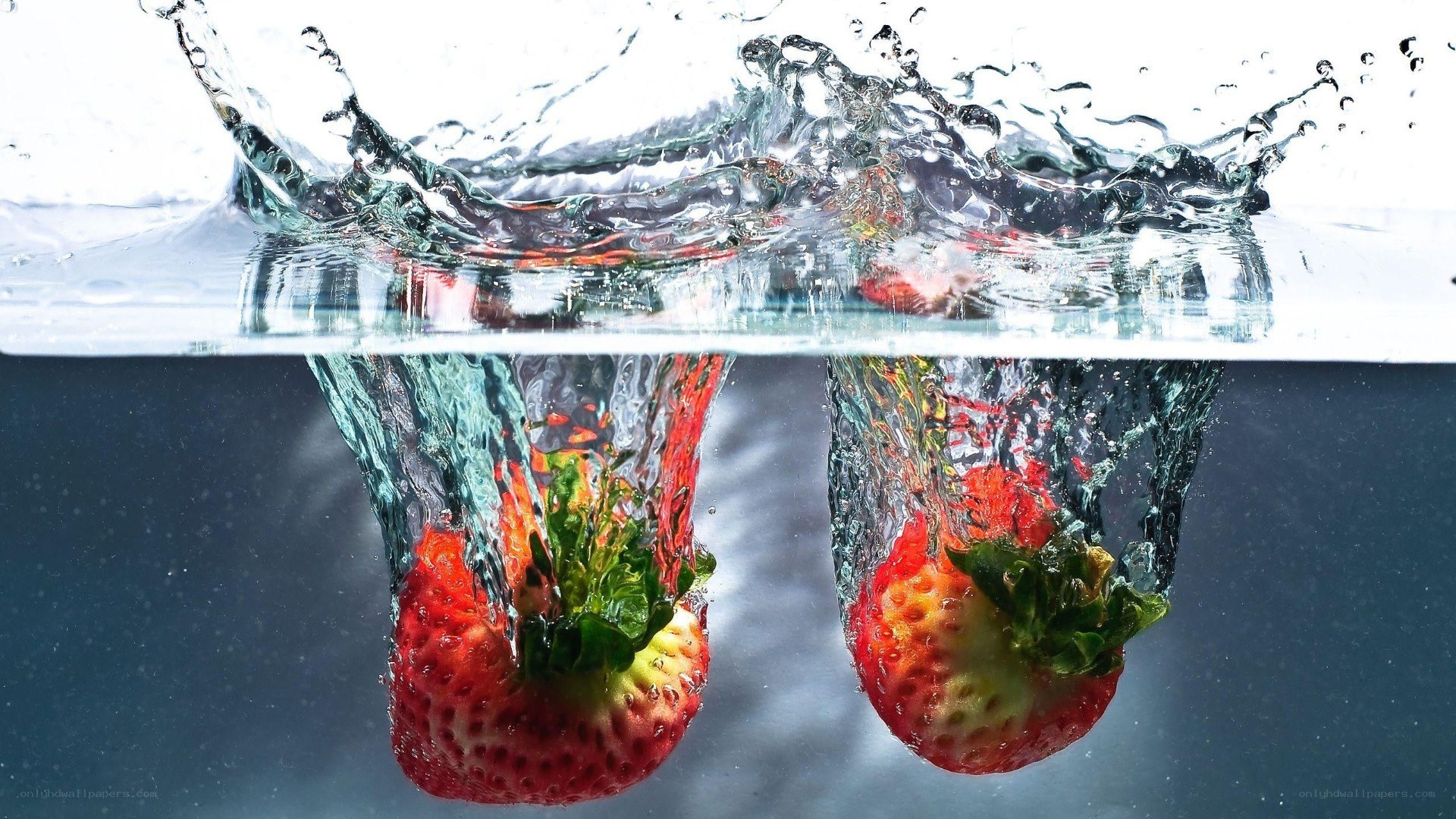 strawberries splashing into water