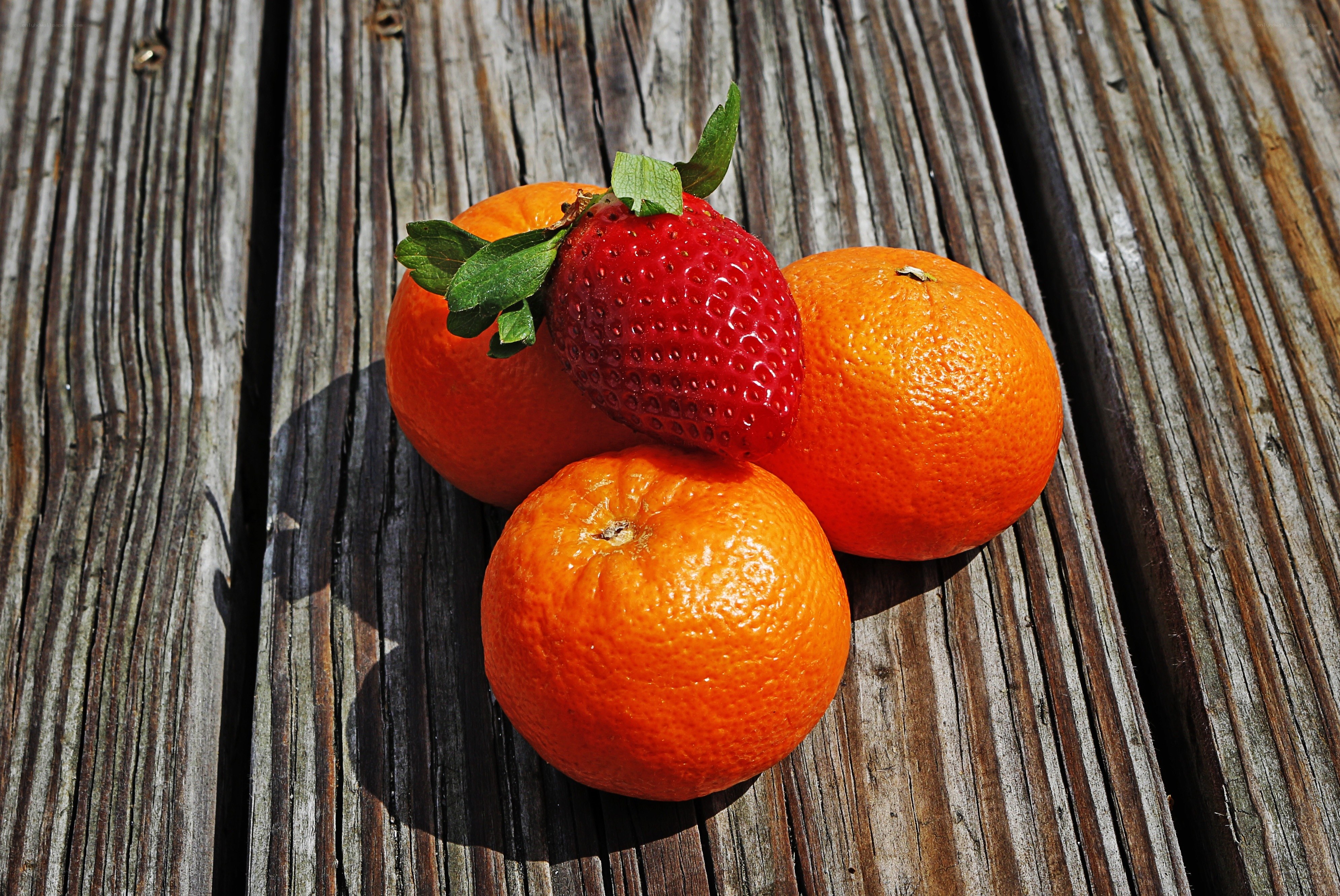 strawberry and oranges on wood
