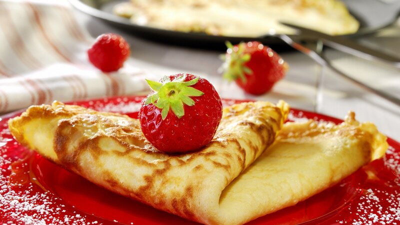 Strawberry crepes on a red plate