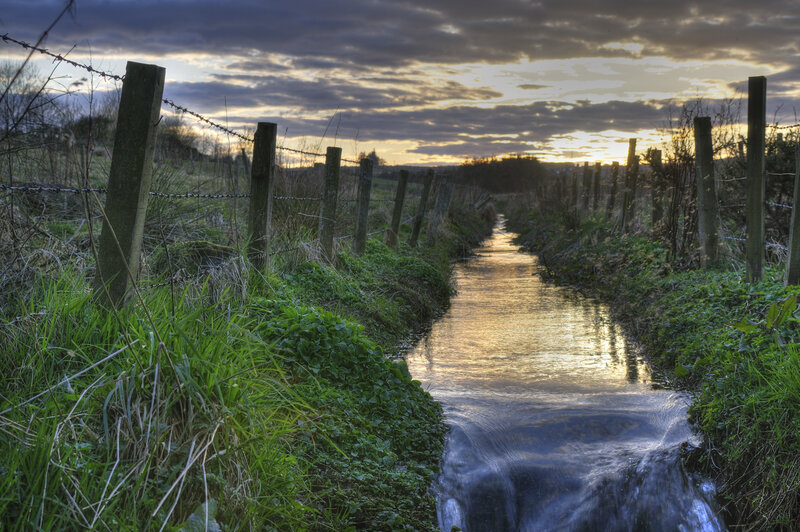 Stream at sunset with fence