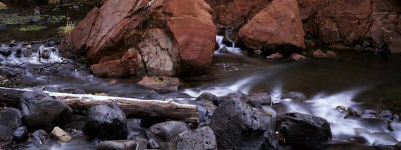 Stream flowing through red rocks