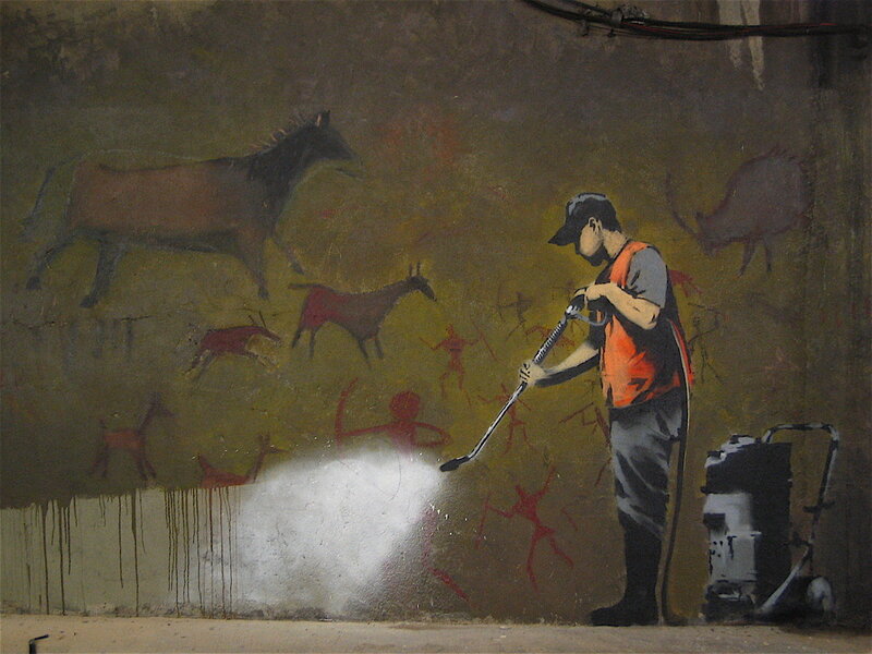 Street artist cleaning cave art