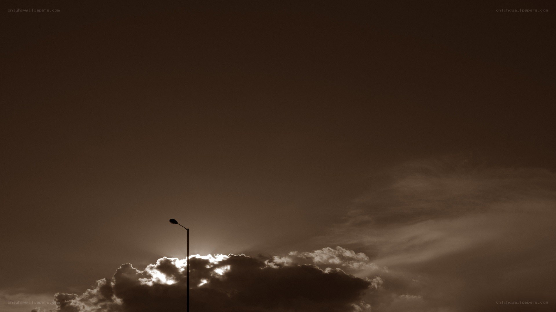 Street lamp silhouetted against clouds