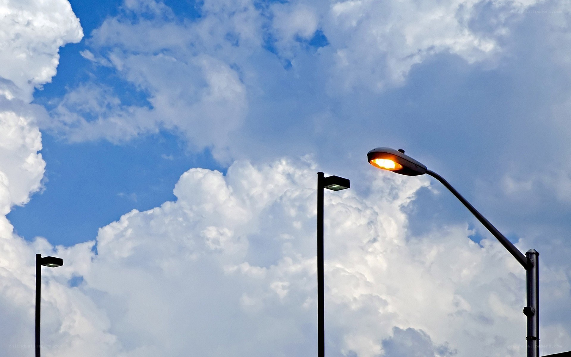 Street lamps against cloudy sky
