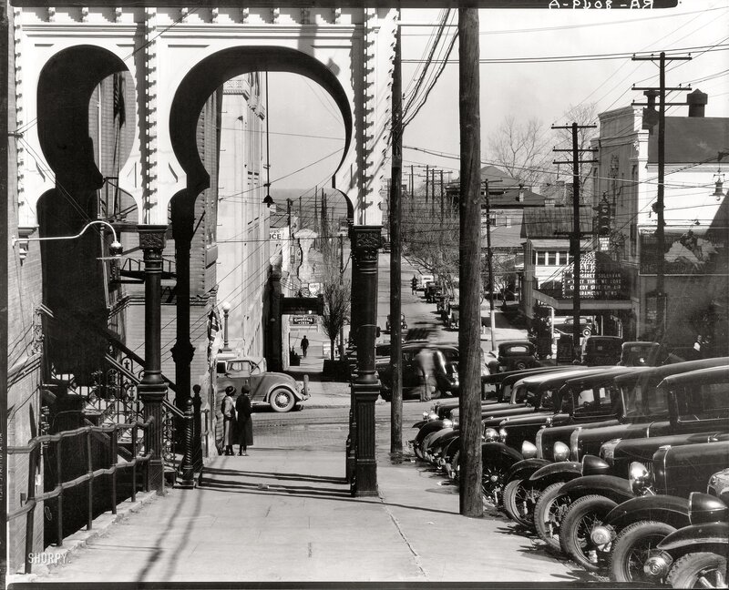 Street scene with arches and vintage cars