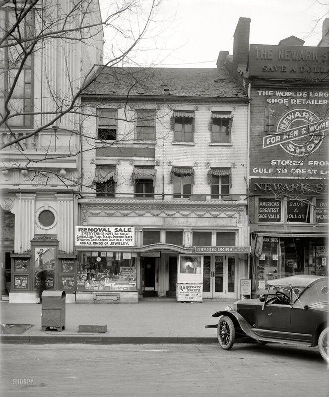 Street scene with vintage cars and storefronts