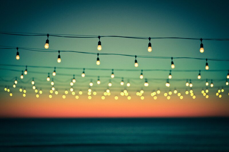 String lights at sunset by the sea