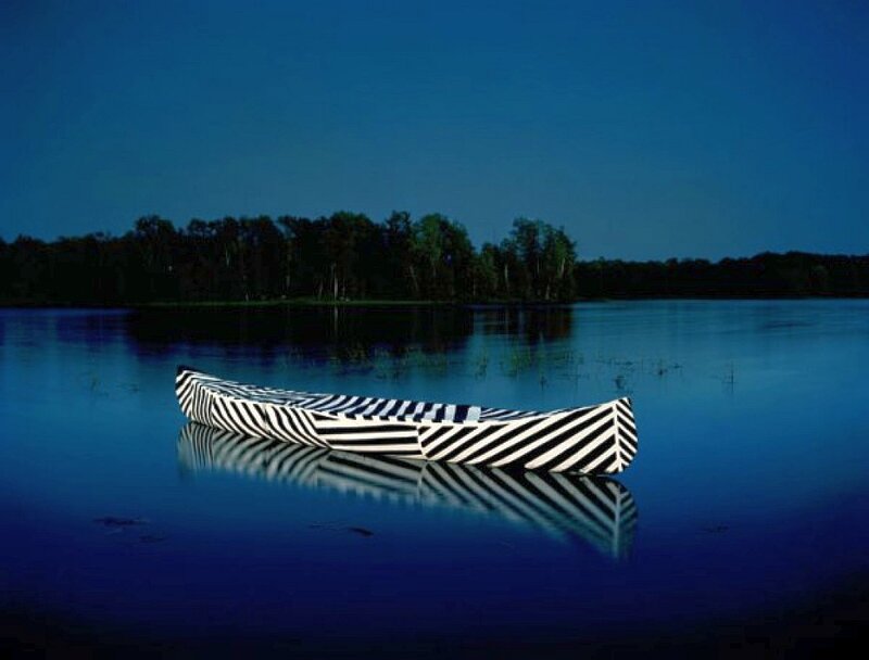 Striped canoe on calm lake