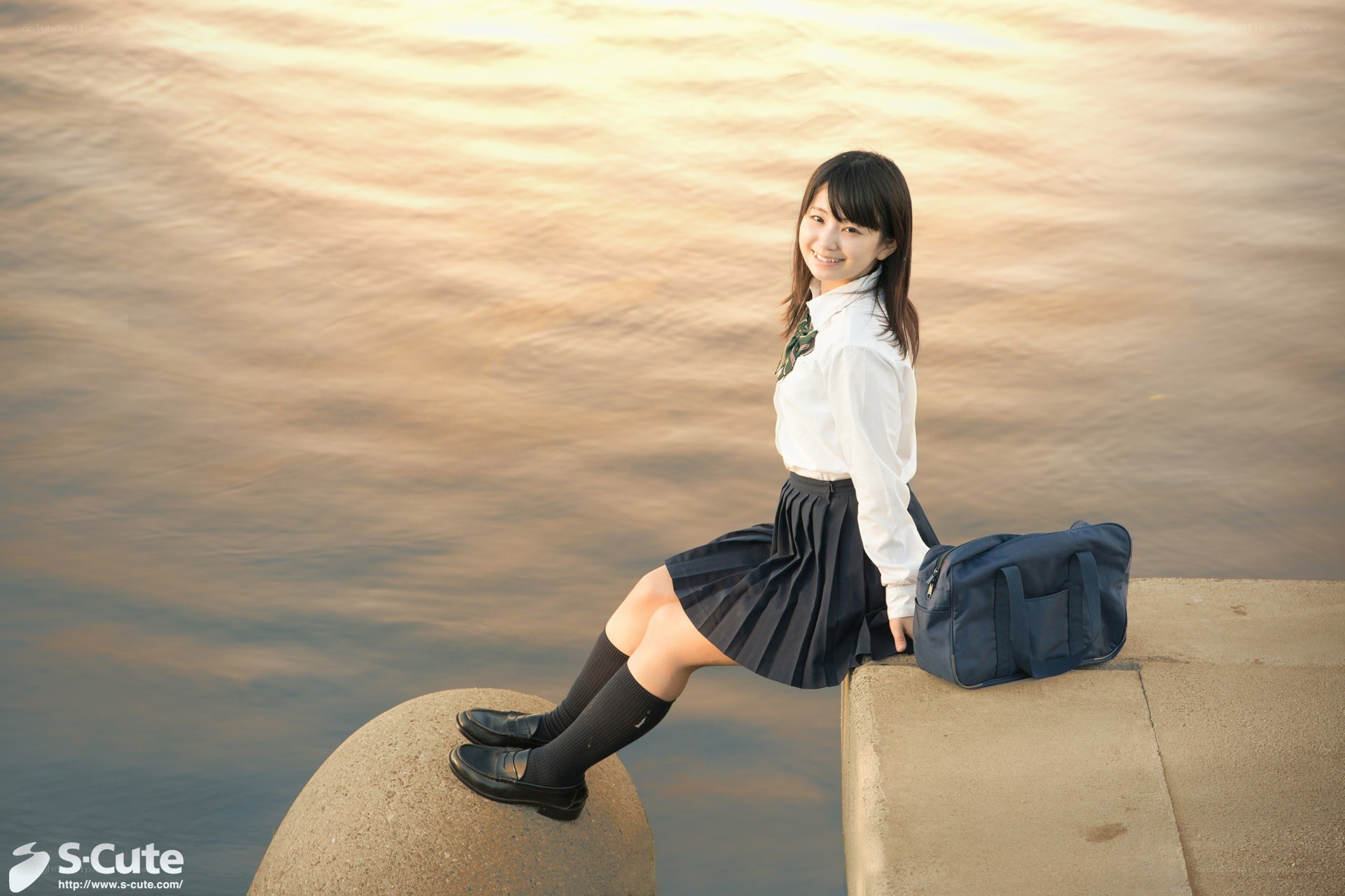 Student by the water at sunset