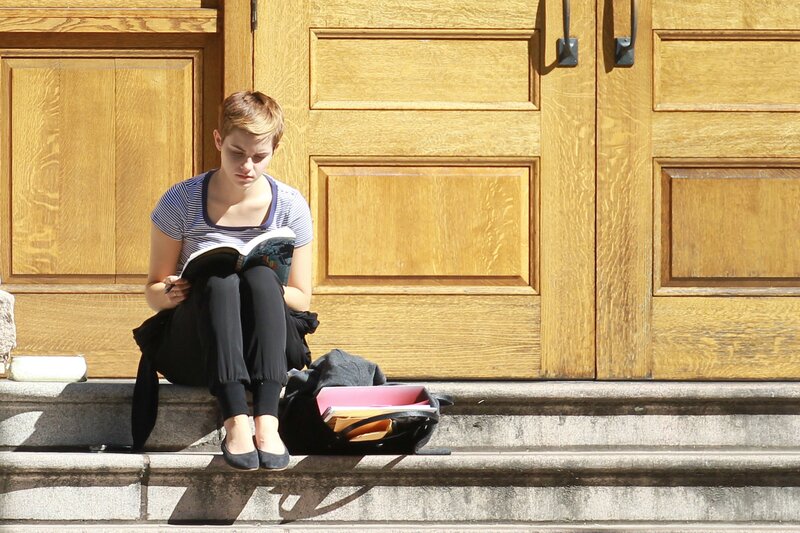 Student reading on steps