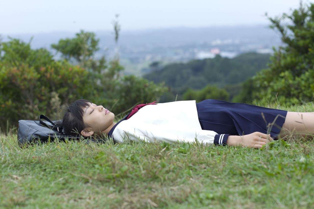 Student resting on grassy hill
