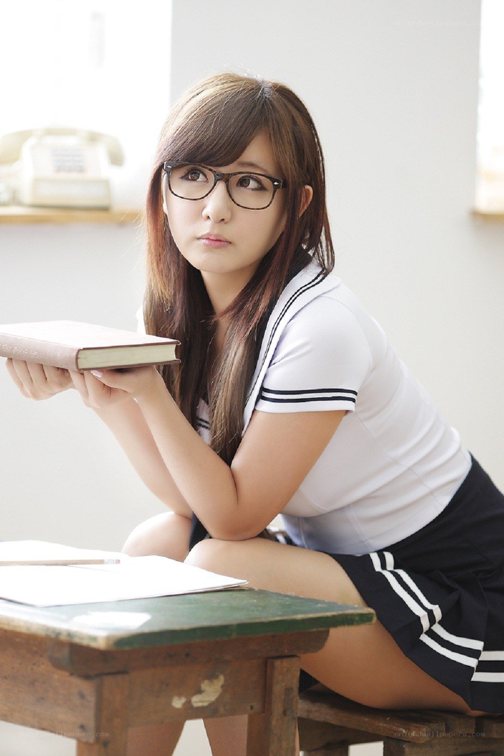 student with book at desk