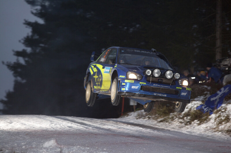 Subaru rally car in mid-air jump