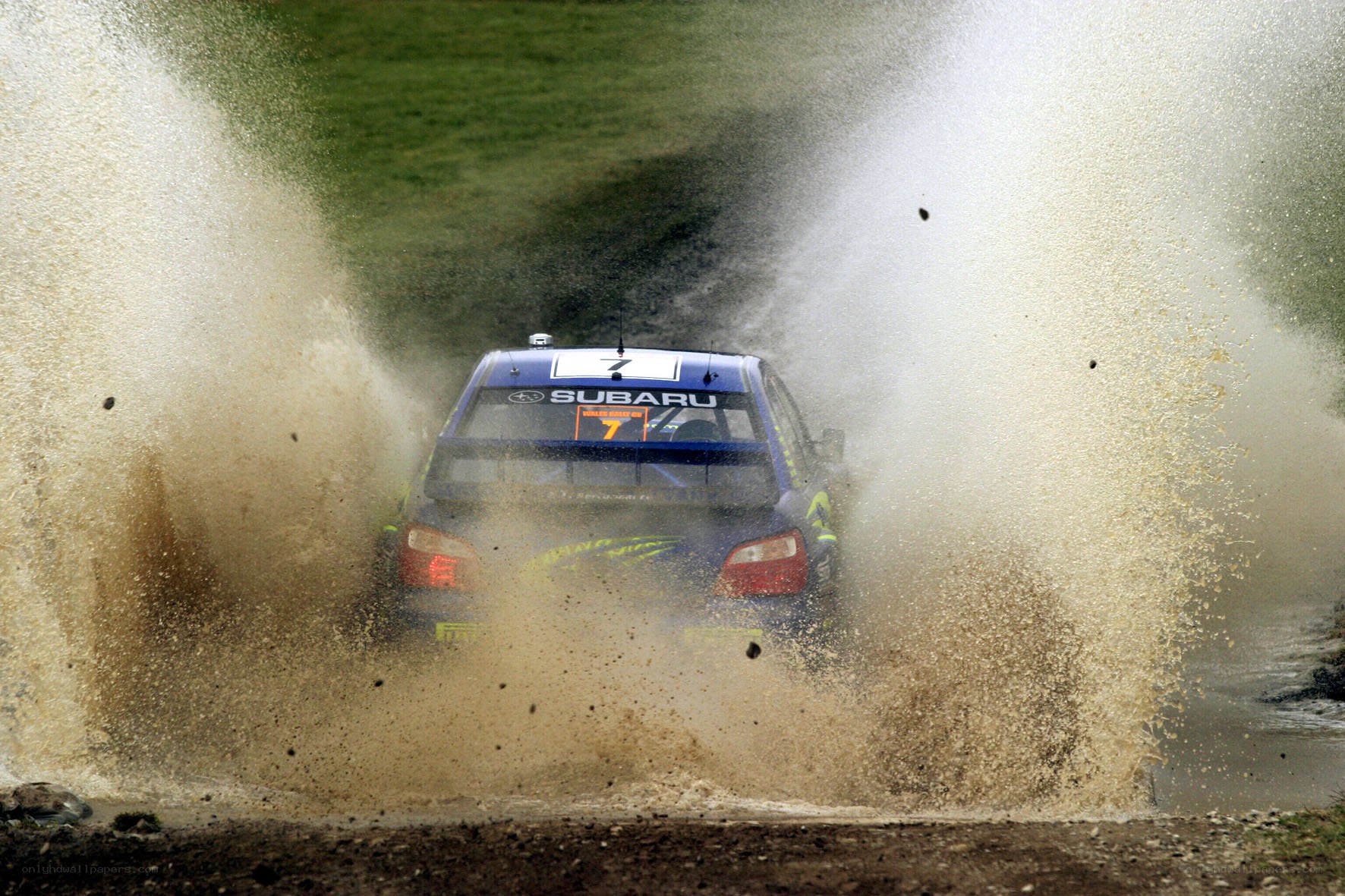 Subaru rally car splashing mud