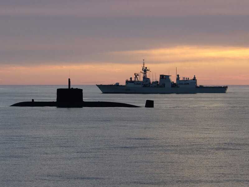 Submarine and warship at sunset