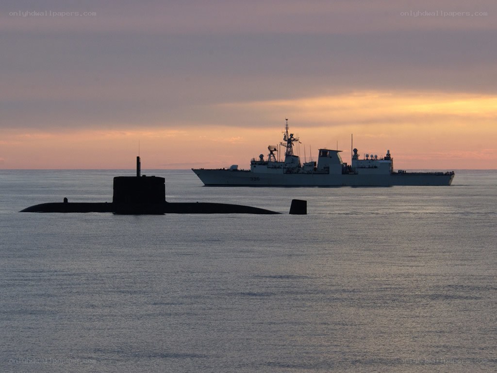 Submarine and warship at sunset