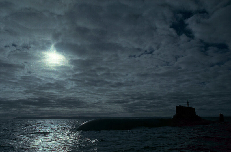 Submarine at sea under cloudy sky