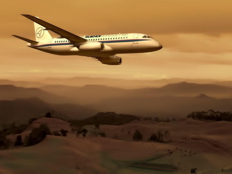 Sukhoi Superjet flying over mountains