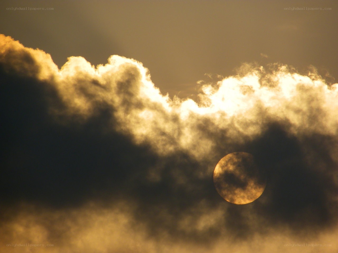 Sun behind clouds at sunset