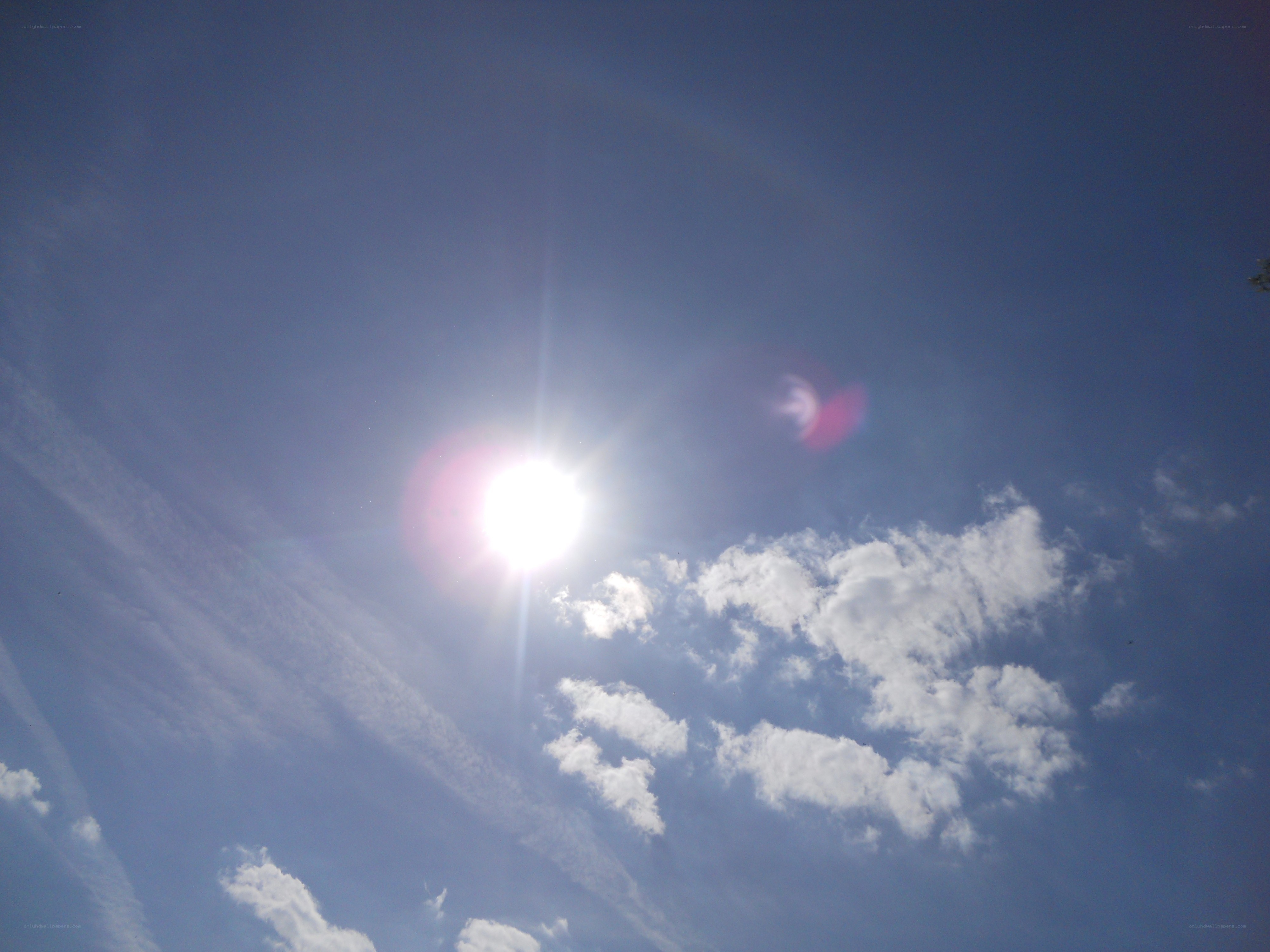 Sun in blue sky with clouds