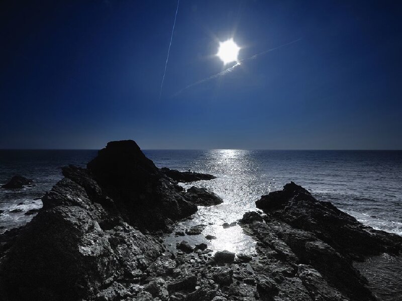 Sun over rocky coastline