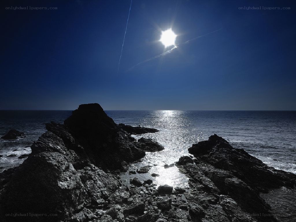 Sun over rocky coastline
