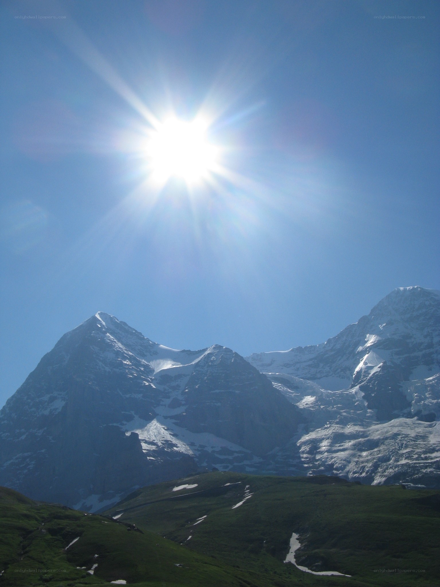 Sun over snow-capped mountains