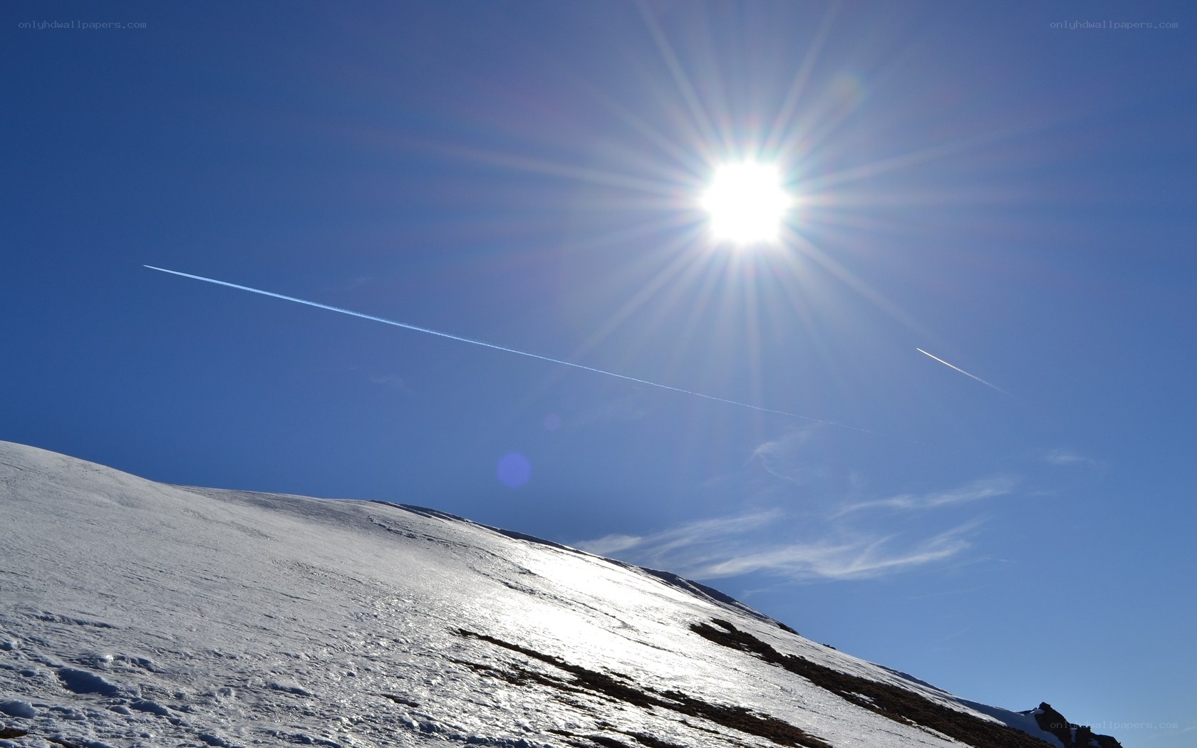 Sun over snowy mountain peak