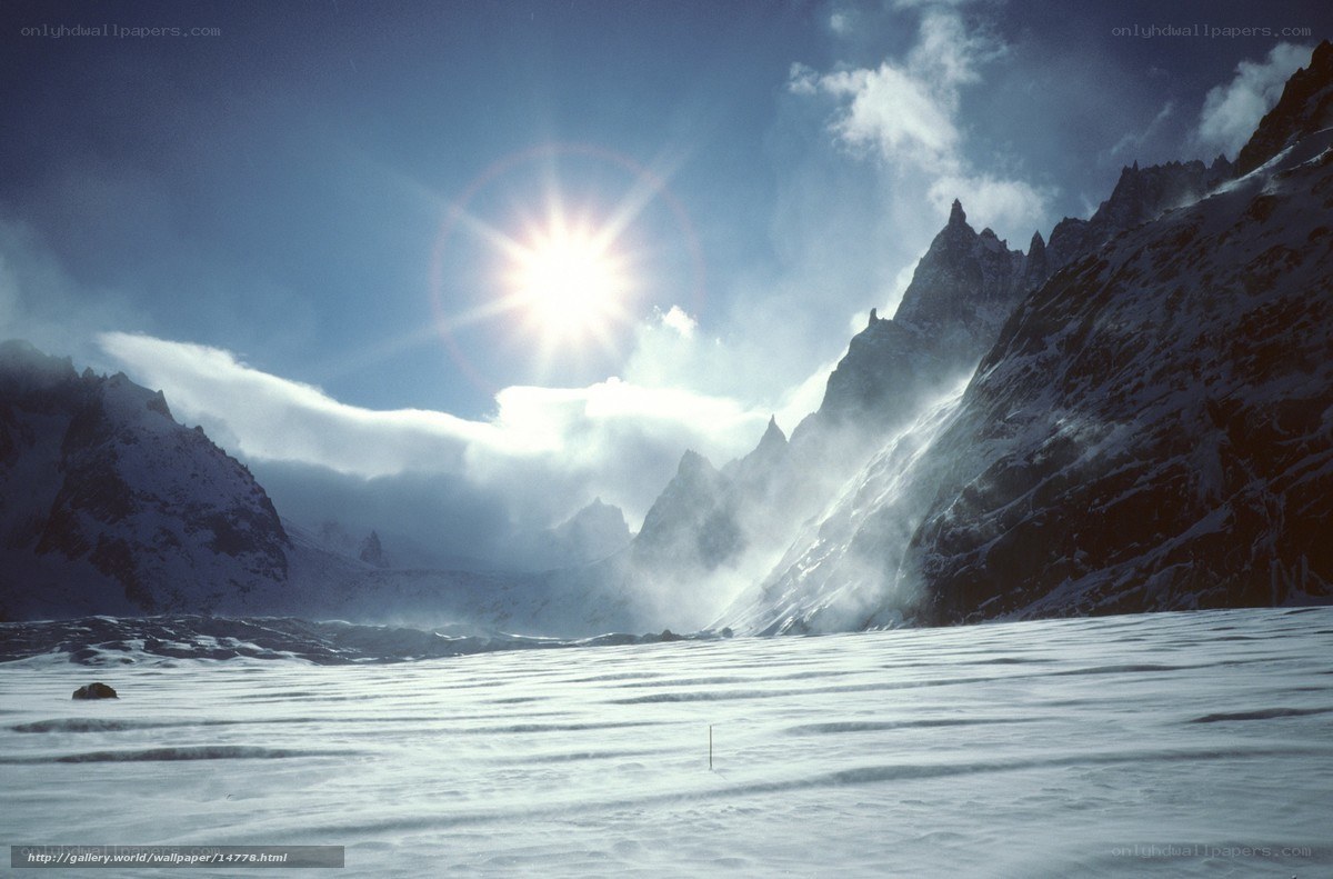 Sun over snowy mountain peaks