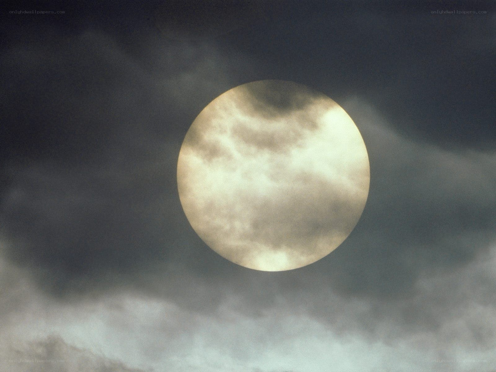 Sun partially obscured by clouds