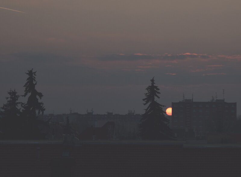 Sun Setting Behind Buildings — Gray