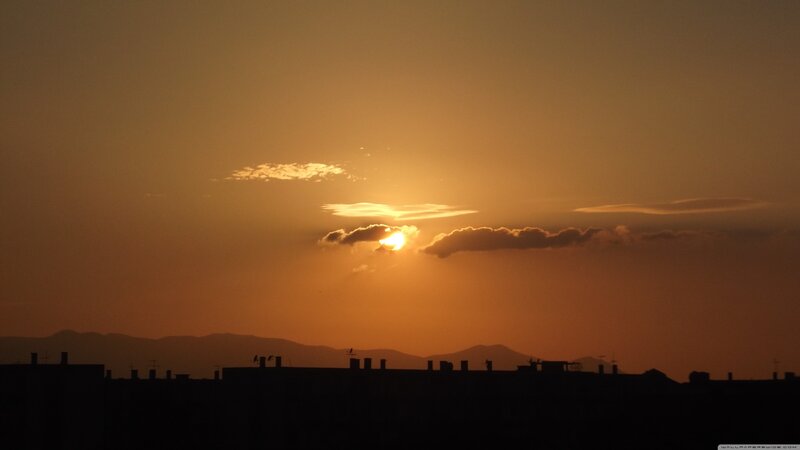 Sun Setting Behind Buildings — Orange
